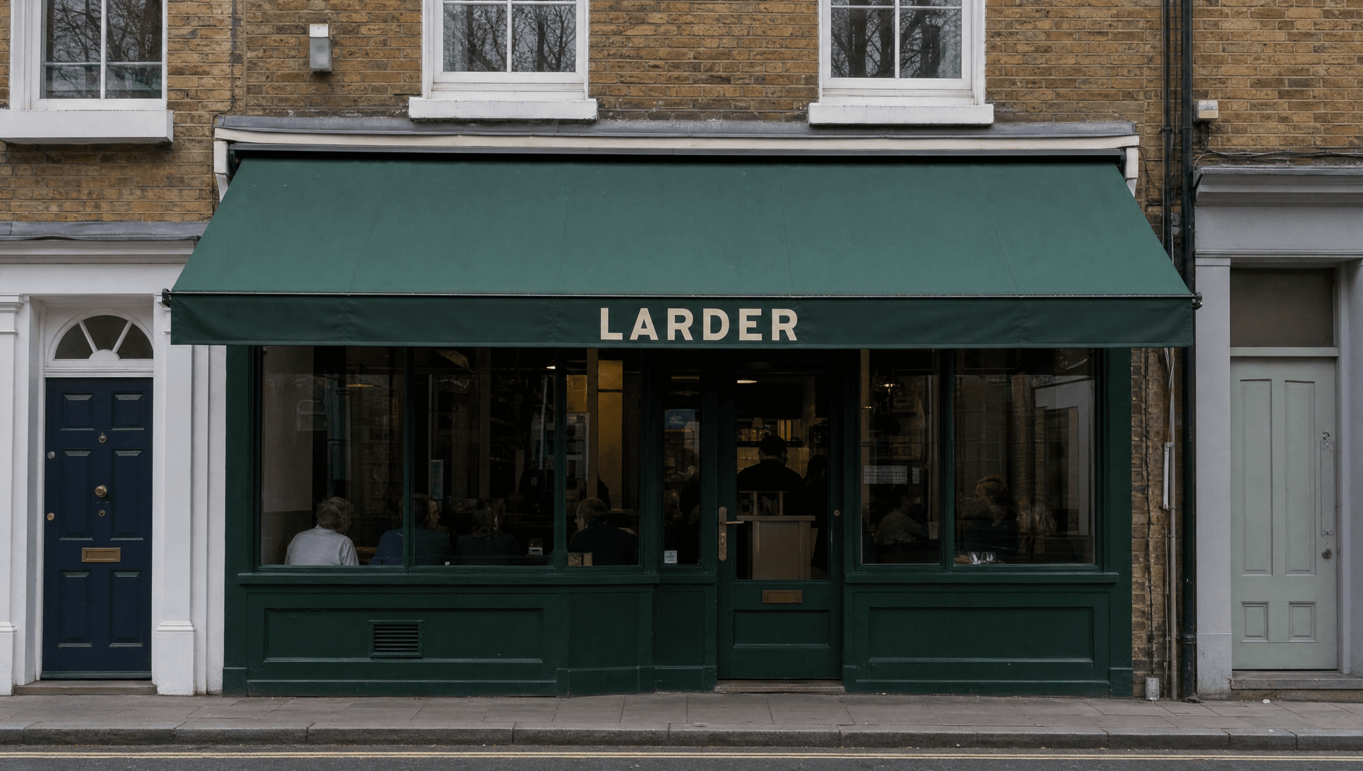 Larder wordmark painted on a street awning